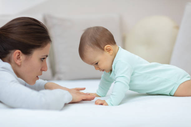 istock Mother and baby playing on the bed 1136048146