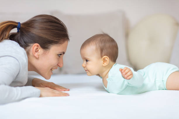 Mother and baby playing on the bed