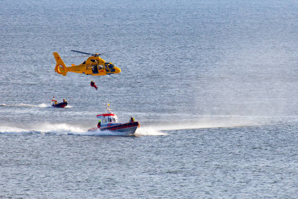 вертолет abseiling человек над морем - rescue helicopter coast guard protection стоковые фото и изображения