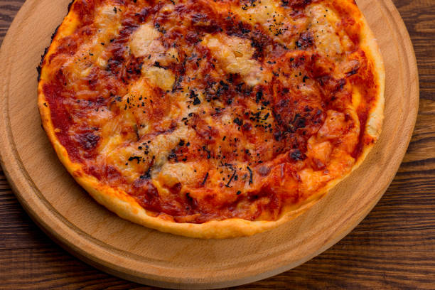 istock Appetizing Homemade Pizza with cheese on a wooden background 1136054664