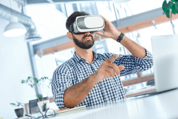 istock Business man using virtual reality headset in the office 1136056220