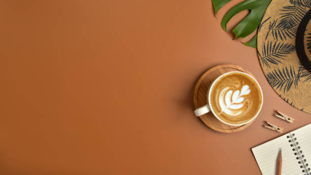 istock Flat lay, top view workspace with eye glasses, notebook, hat, pencil, green leaf, shoes and coffee cup on brown background. Summer stylish traveller blogger concept. 1136057328