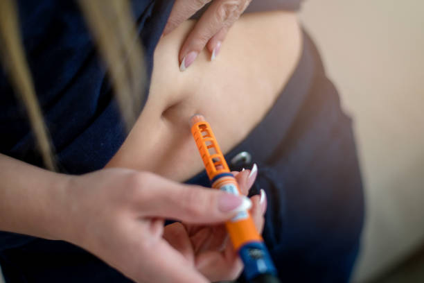la jeune femme injecte l'insuline avec un stylo d'insuline - insulin diabetes pen injecting photos et images de collection