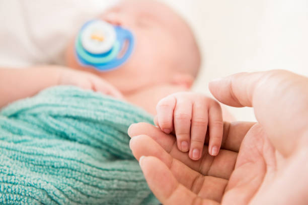 istock Cute sleeping baby holding hand of father 1136060768