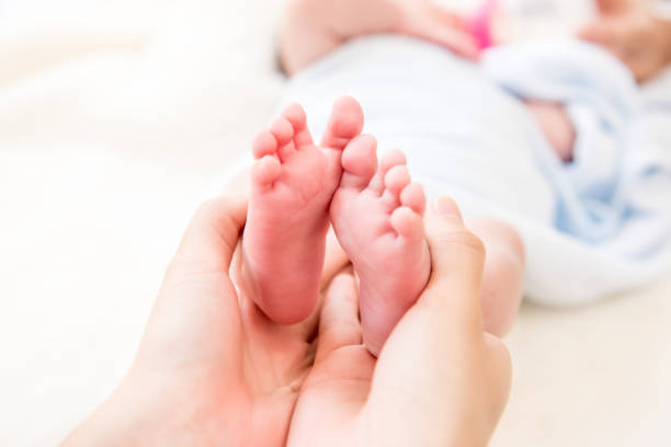 istock Mother hands gently holding small baby feet 1136060814