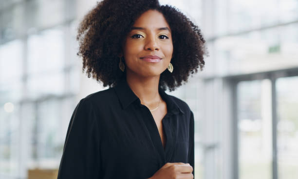 I may be young, but I'm driven Cropped shot of a confident young businesswoman walking through a modern office brightly lit stock pictures, royalty-free photos & images