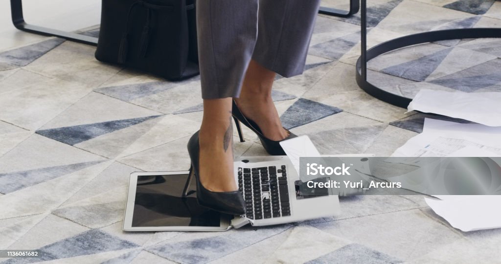 She's had enough of technology Cropped shot of an unrecognizable businesswoman breaking a laptop by jumping on it in an office Computer Stock Photo