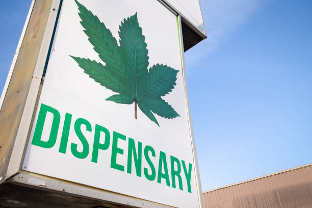 A cannabis dispensary sign with a large marijuana leaf on it. A cannabis dispensary sign with a large marijuana leaf on it legalization photos stock pictures, royalty-free photos & images