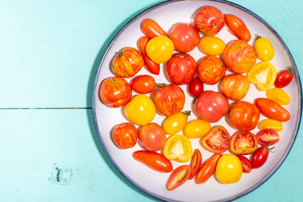 istock Tomatoes and plate on green wooden table 1136067800