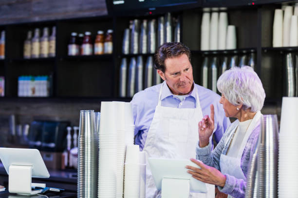 istock Workers in coffee shop at cash register 1136072917