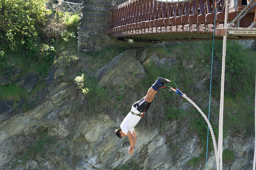 In motion having leapt off AJ Hackett's Kawarau River Bungy  jump facility from bridge across river October 2018 Queenstown New Zealand