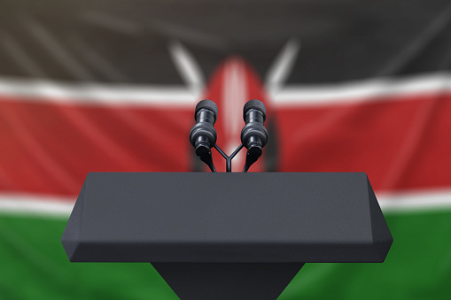 Podium lectern with two microphones and Kenya flag in background