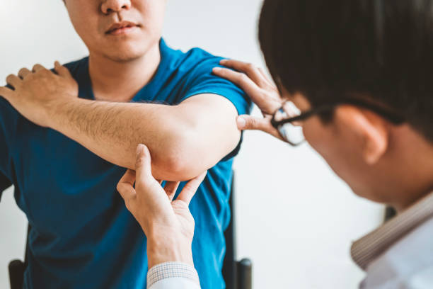 istock Physical Doctor consulting with patient About elbow muscule pain problems Physical therapy diagnosing concept 1136089190