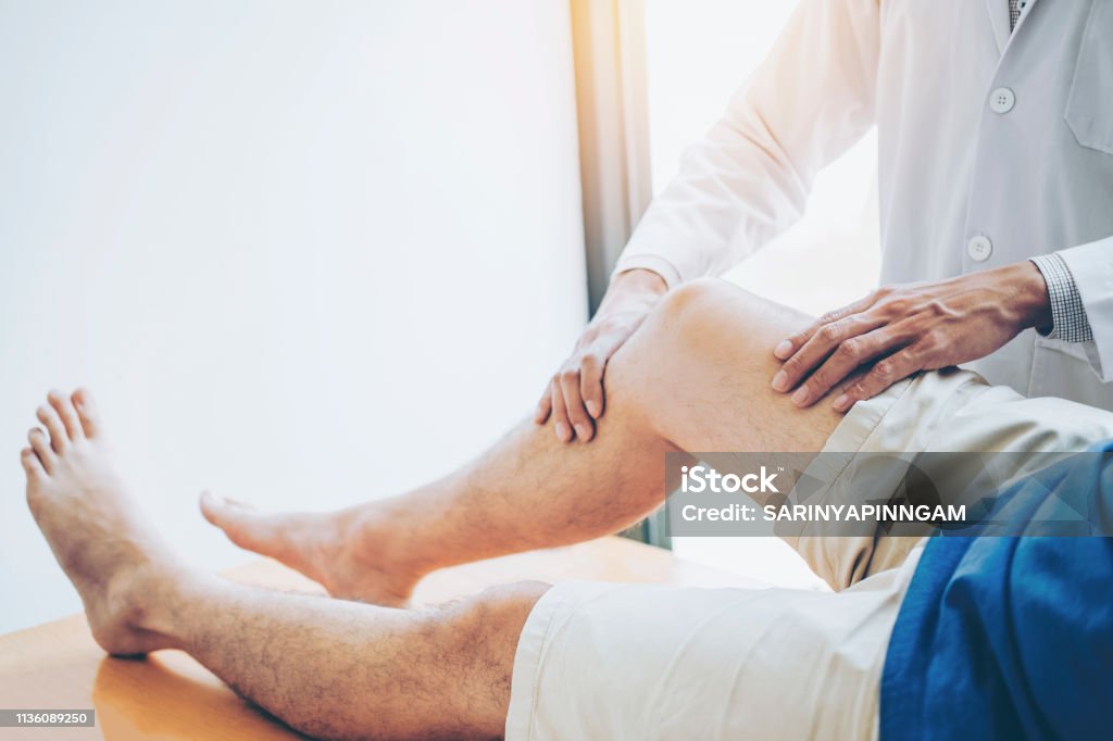 Médecin physique consultant avec le patient problèmes de genou concept de thérapie physique - Photo de Genou libre de droits