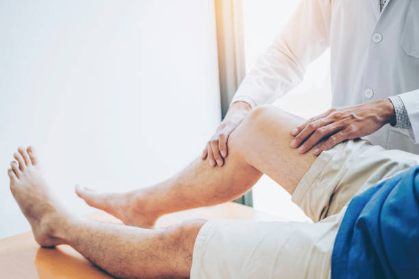 consulenza del medico fisico con il paziente problemi al ginocchio concetto di terapia fisica - osteopata foto e immagini stock