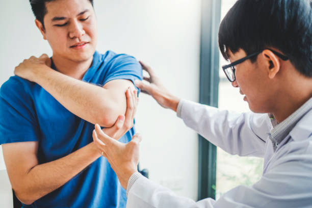 istock Physical Doctor consulting with patient About elbow muscule pain problems Physical therapy diagnosing concept 1136089266