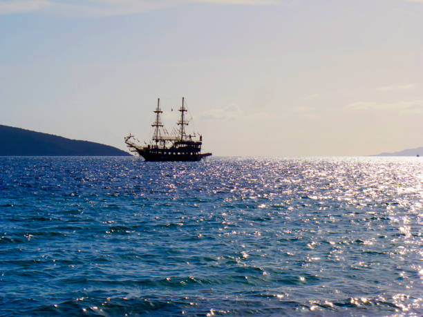 Aerial view of a three-masted sailing ship with sails and a large Brazilian flag on the stern sailing in the Atlantic Ocean. The training ship of the Brazilian Navy.