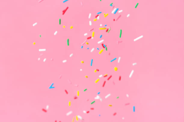 istock soaring down colorful sprinkles over pink background 1136092690