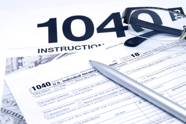 istock Income tax form with instruction, glasses and pen 1136094871