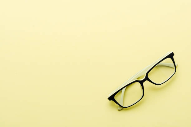 istock Modern spectacles eye glass isolated on yellow background. Top view. 1136097462