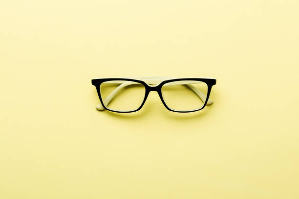 istock Modern spectacles eye glass isolated on yellow background. Top view. 1136097483