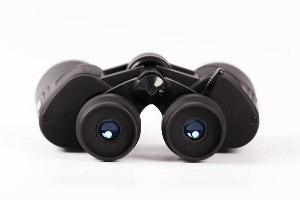 istock Black binoculars with orange lens isolated on white background 1136097766