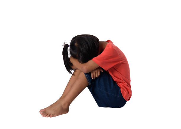 istock Sad little asian boy sitting on floor isolated on white background 1136099649