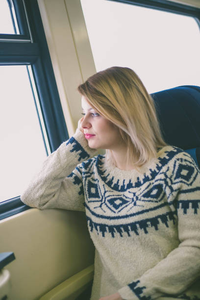 istock Young woman traveling looking out the window while sitting in the train. 1136101558