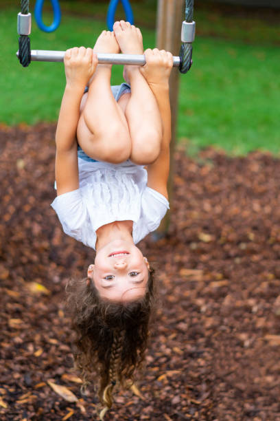istock child girl upside down on playground 1136108975