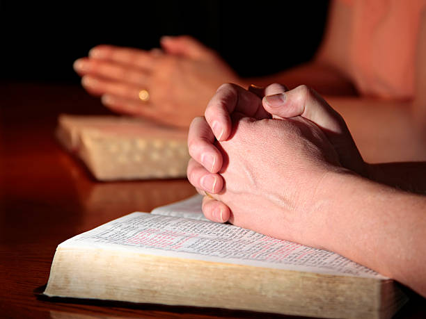 istock Man and Woman Praying with Holy Bibles 113611156