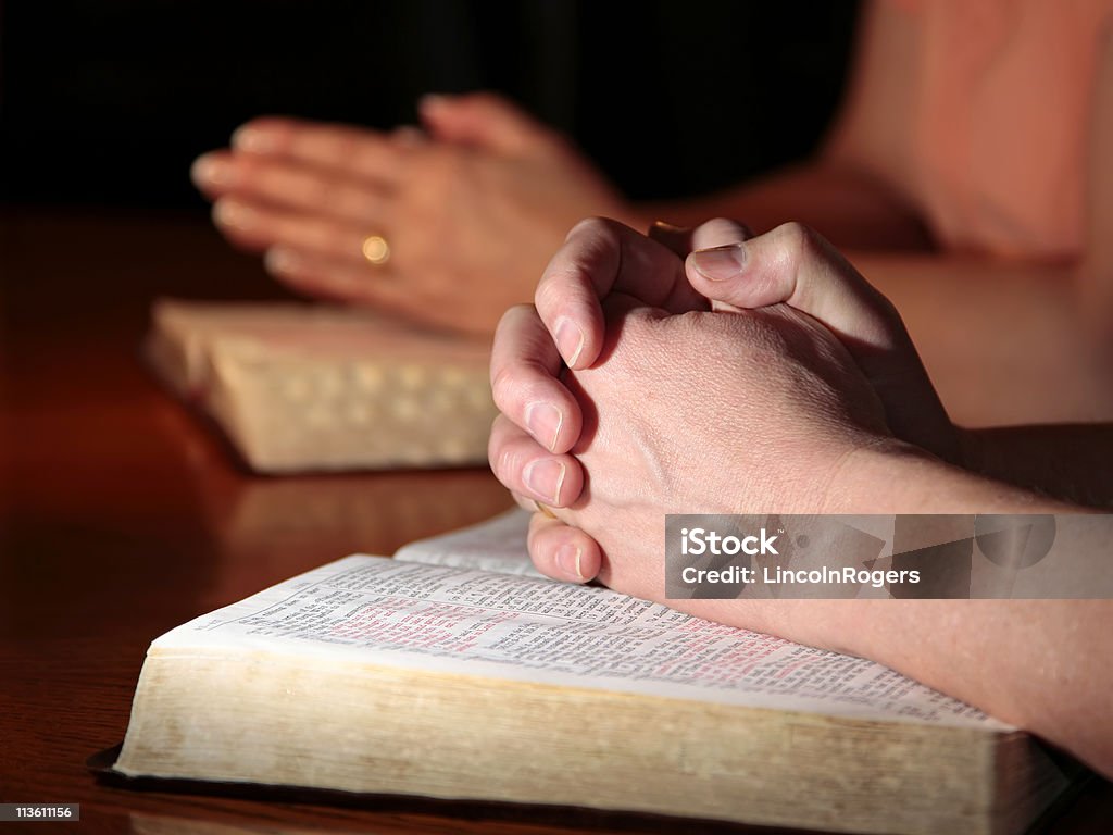 Man and Woman Praying with Holy Bibles  Adult Stock Photo