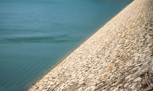 Textures and backgrounds of Asia. Dam reservoir in the mountains. Texture of water and masonry. Vietnam.