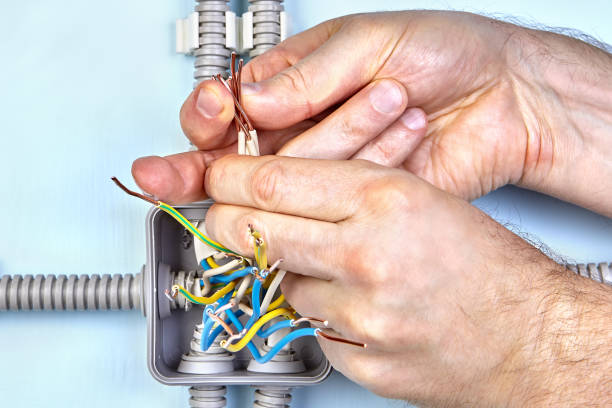 istock Electrician twists wires together by hands. 1136129378