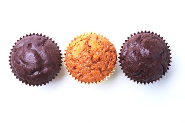 istock Assorted with Delicious homemade cupcakes with raisins and chocolate isolated on white background. Muffins. Top view. 1136132082
