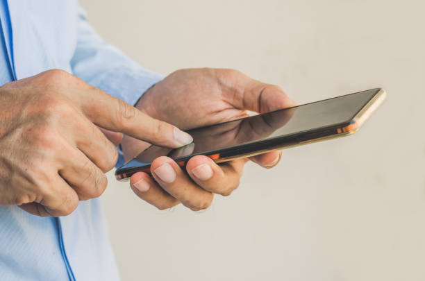 istock businessman using mobile phone touching screen in office with hands typing smart phone texting messaging lifestyle working app device technology internet social data online concept vintage style. 1136132259