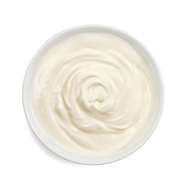 Sour cream in bowl, mayonnaise, yogurt, isolated on white background. Top view. stock photo