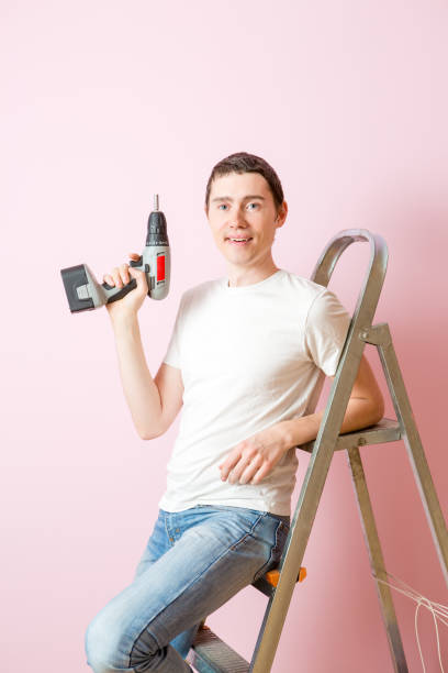 istock Image of man with drill near ladders 1136135351