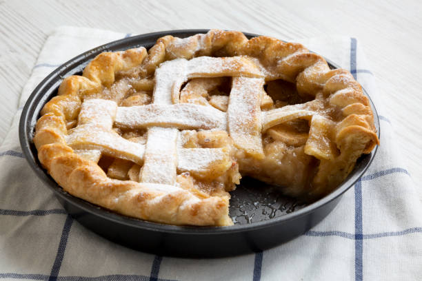 istock Home-baked apple pie on white wooden surface, side view. Close-up. 1136135434
