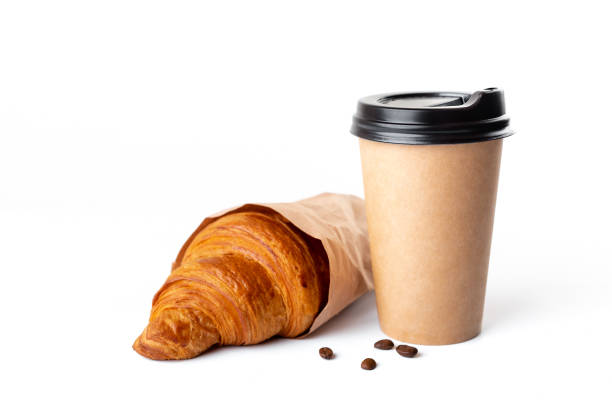 Paper coffee cup with croissant Paper coffee cup with croissant isolated on white background. Studio light. Food and drink photo. Good morning concept. disposable photos stock pictures, royalty-free photos & images
