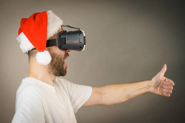 istock Man in virtual reality goggles and santa hat 1136142691