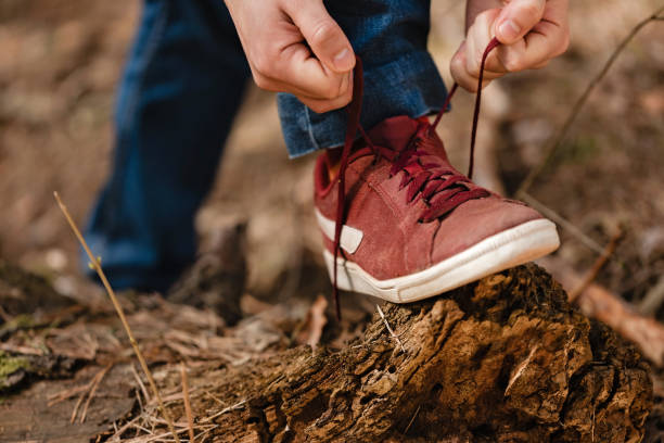 istock Man tying shoelace in the forest. 1136143585