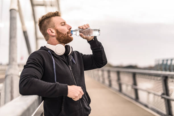 istock Sporty mid adult man drinking water after exercise. 1136149042
