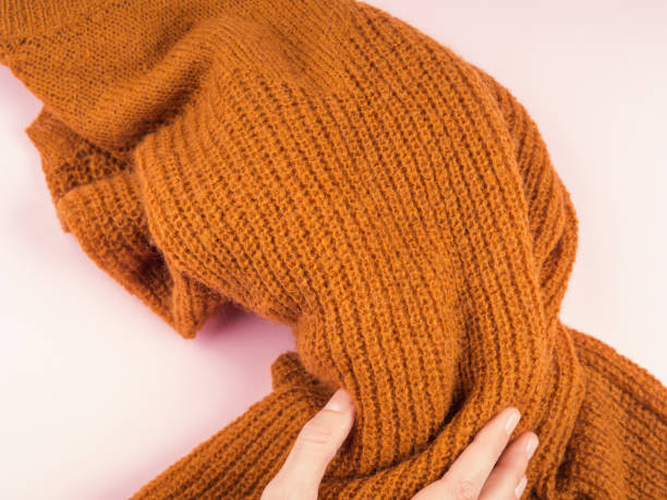 istock Yellow sweater on pink with woman's hand 1136149166