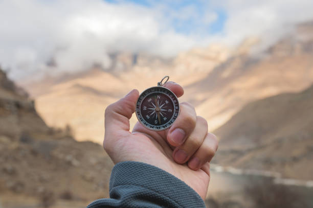 istock A male Hiker is looking for a direction with a magnetic compass in the mountains in the fall. Point of view shot. Man's hand with a watch bracelet holds a compass 1136149193
