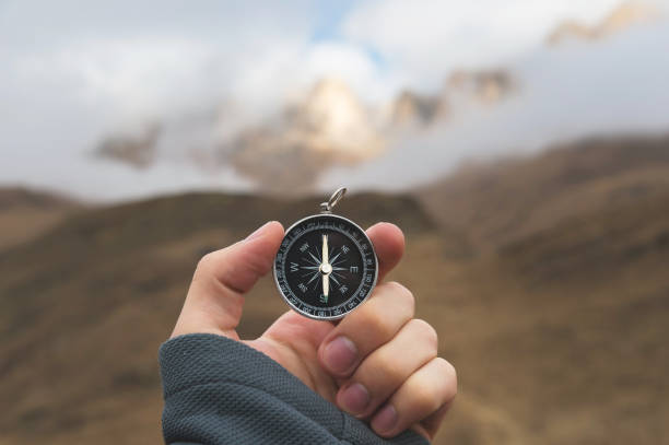istock A male Hiker is looking for a direction with a magnetic compass in the mountains in the fall. Point of view shot. Man's hand with a watch bracelet holds a compass 1136149201