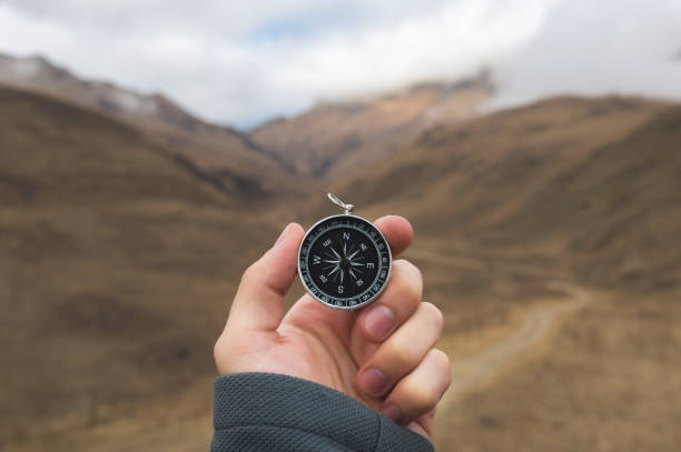 istock A male Hiker is looking for a direction with a magnetic compass in the mountains in the fall. Point of view shot. Man's hand with a watch bracelet holds a compass 1136149208