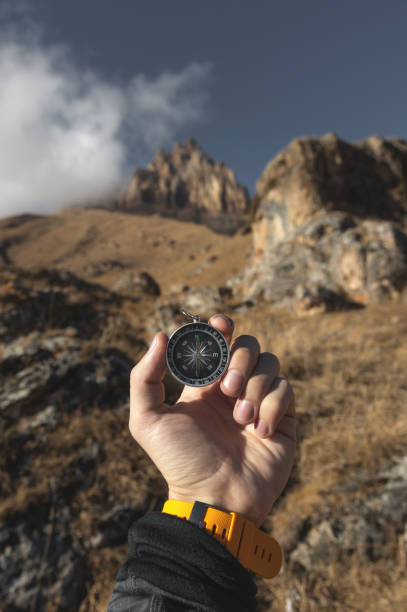istock A male Hiker is looking for a direction with a magnetic compass in the mountains in the fall. Point of view shot. Man's hand with a watch bracelet holds a compass 1136149262
