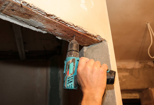 istock Man in using electric drill for doors. Maintenance repair works renovation in the flat. Restoration indoors. Concrete background. 1136150764