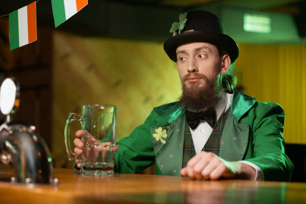 istock Dark-haired bearded young man in a leprechaun costume looking thoughtful 1136151775