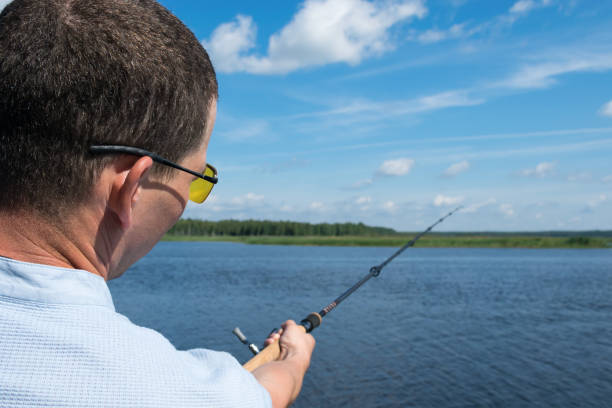 istock fishing on the river in good weather back view, close-up 1136156455
